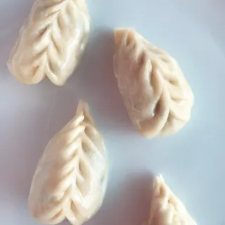 Ravioli vegetariani crudi, chiusi a mano con la chiusura a spiga